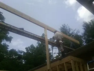 Carpenter setting a ridge beam over a new addition frame — Ice Dam Removal by Roofing Brothers in Gregory