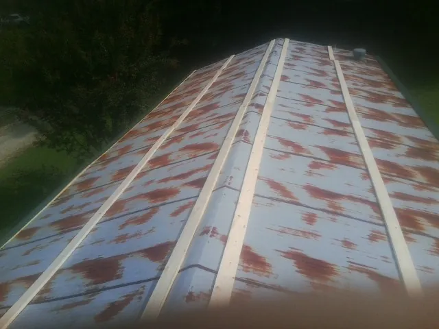Rusted metal roof panels with new wood purlins before replacement — Storm Damage Roof Repair in Gregory by Roofing Brothers