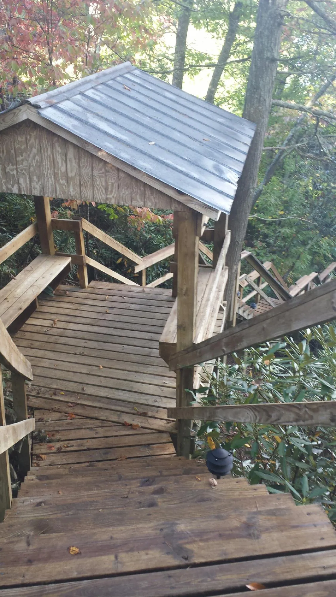 Metal roofed shelter over wooden steps on a wooded walkway — Skylight Repair & Installation work by our crew in Gregory