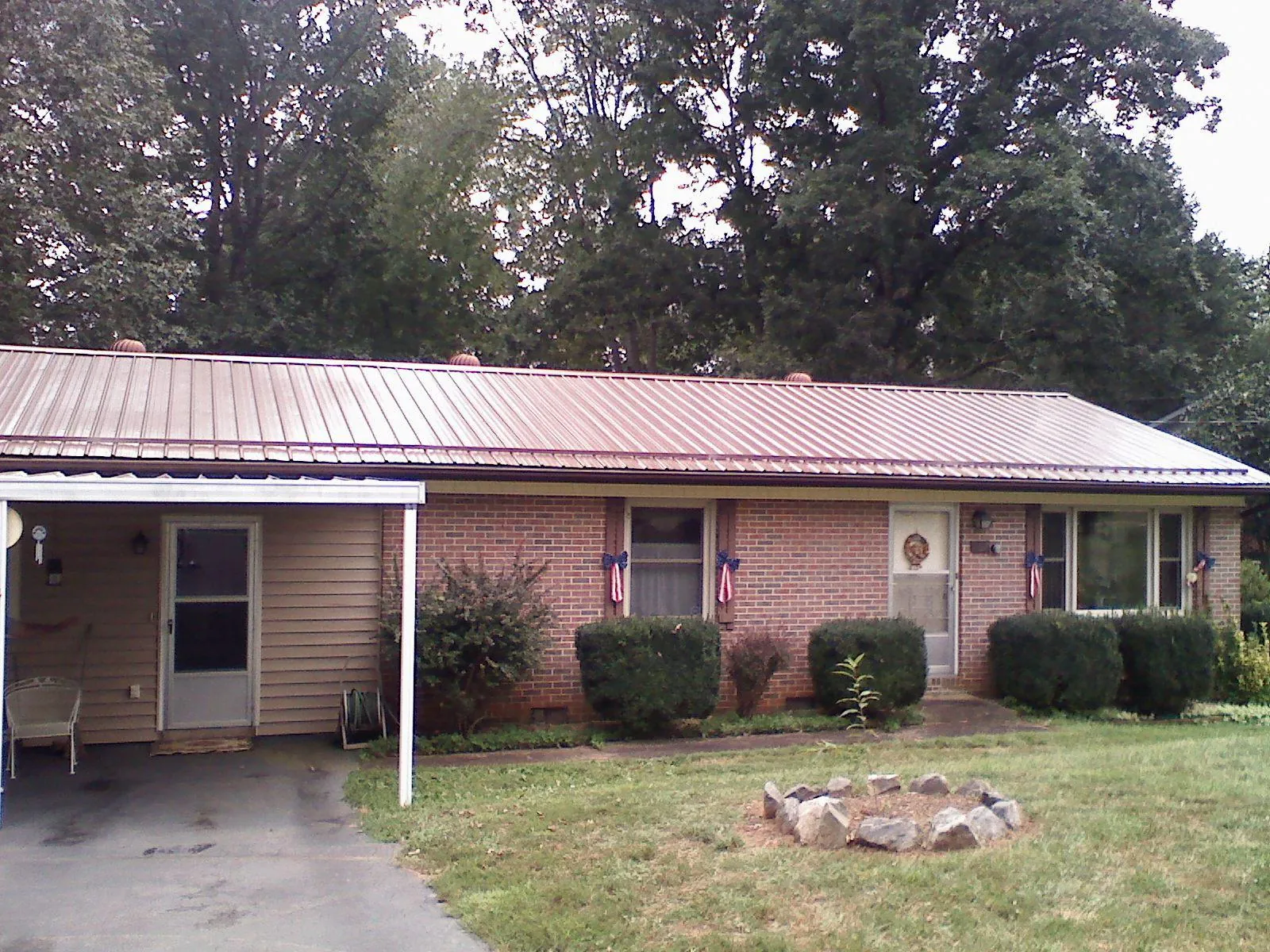Bronze metal roof and carport on a brick ranch home — Roof Repair work by our crew in Gregory